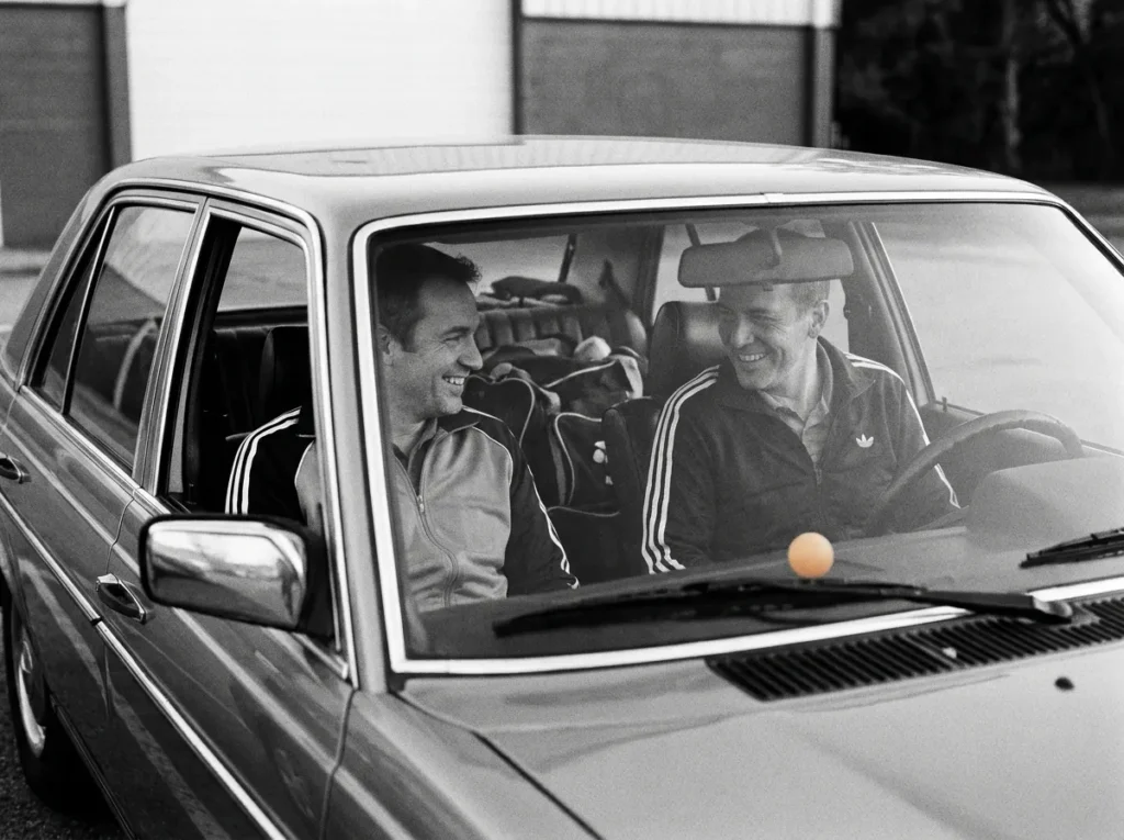 Zwei Spieler lächeln im Auto, Sporttaschen auf dem Rücksitz